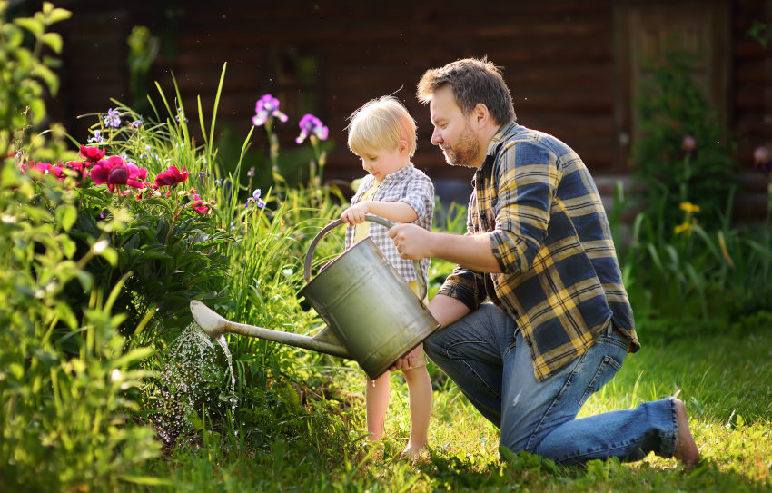 Otrok z očetom zaliva vrt